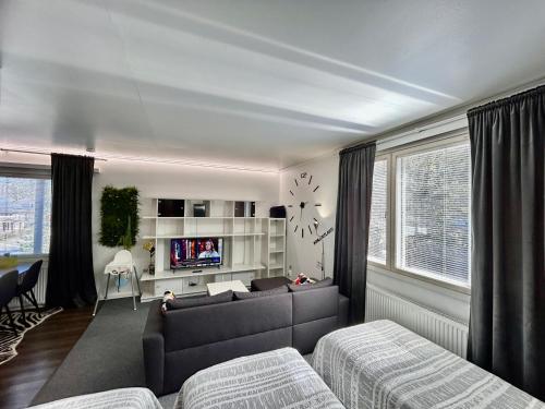 a living room with a couch and a tv at ChillOut Studio Apartment Lahti in Lahti