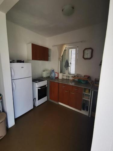 a kitchen with a white refrigerator and a stove at Villa Anlave in Sveti Stefan
