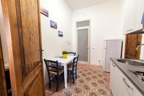 a kitchen with a table and two chairs and a refrigerator at Fardella 250 in Trapani