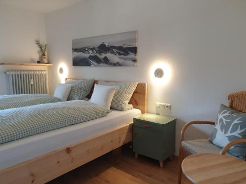um quarto com uma cama e uma cadeira em Haus Sabine Fewo Bergliebe em Wallgau