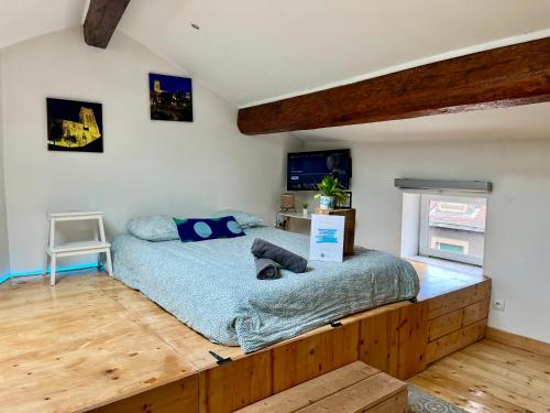 a bedroom with a bed with a wooden frame at L'appart & bleu studio in LʼArbresle