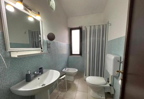een badkamer met een wastafel, een toilet en een spiegel bij B&B Villa Da Antonio in Caltanissetta