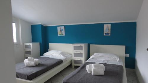 two beds in a room with blue walls at BlueMind Freedom in Tropea