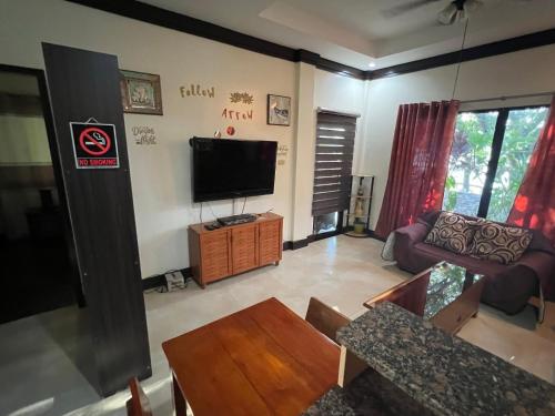a living room with a television and a couch at Adayo Cove Resort in Siquijor
