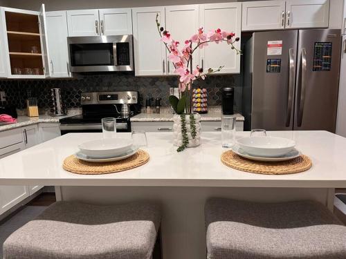 a kitchen with a table with two plates and a refrigerator at Healing Haven King Bed Suite in Dallas