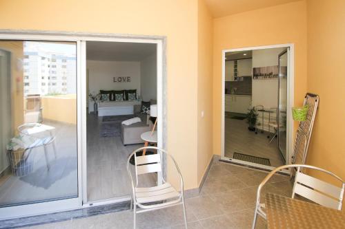 a living room with a sliding glass door and chairs at Apartment Praia Rocha Tropical in Portimão