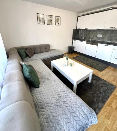 een woonkamer met een bank en een tafel bij Apartman Lara Laktasi in Laktaši