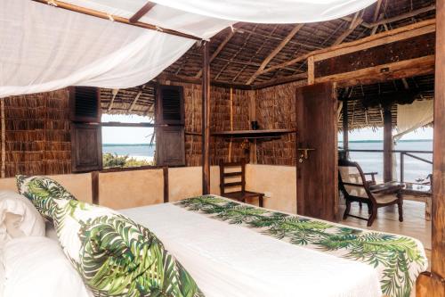 a bedroom with a bed and a view of the ocean at The Cabanas Lamu in Lamu