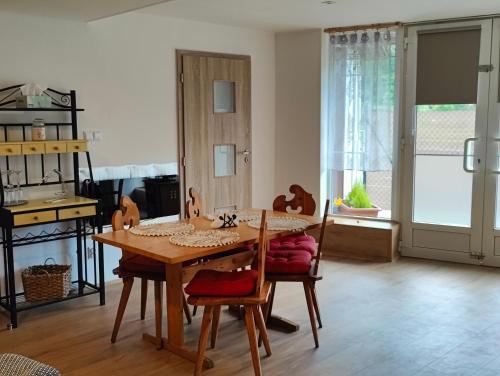 ein Esszimmer mit einem Tisch, Stühlen und einem Fenster in der Unterkunft Apartmán HRANICE - Hřensko in Hřensko