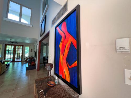 uma grande pintura numa parede numa sala de estar em Villa Iris 2 story ocean view villa w/ pool access em Vega Alta