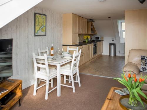 a kitchen and living room with a table and chairs at The Wheelhouse in Fowey