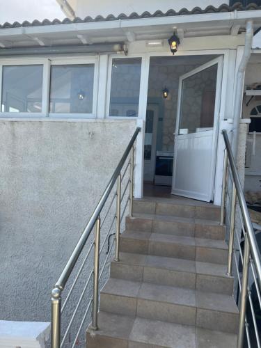 a set of stairs leading to a house with a door at Hamre Apartments (Nicholas) in Agios Georgios Pagon