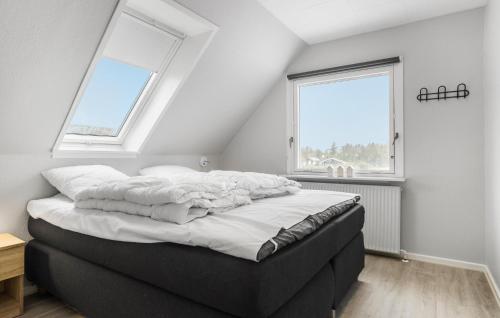 a bed with white sheets in a room with two windows at Lovely Home In Vestervig With Wifi in Vestervig