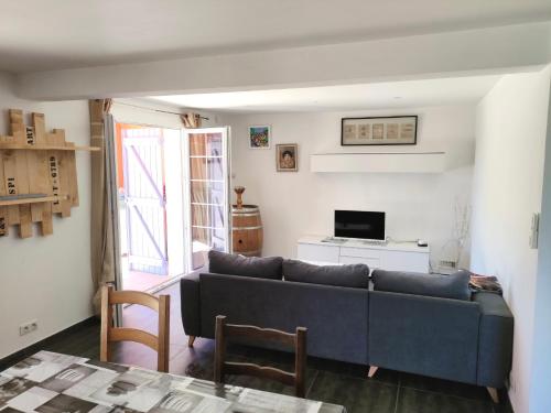 uma sala de estar com um sofá azul e uma mesa em Jolie bas de villa entre mer et campagne em Ollioules