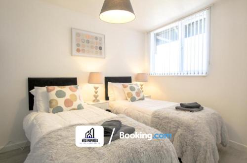 1 dormitorio con 2 camas y ventana en 2 Bed Apt City Centre By NYOS PROPERTIES Short Lets & Serviced Accommodation, en Mánchester
