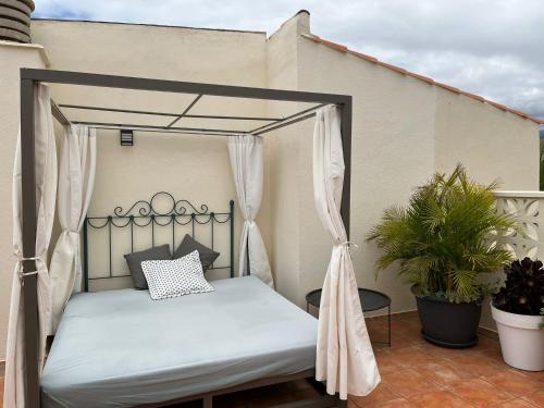 una cama con dosel en un patio con una planta en Dachterrassen Wohnung Teneriffa, en Callao Salvaje