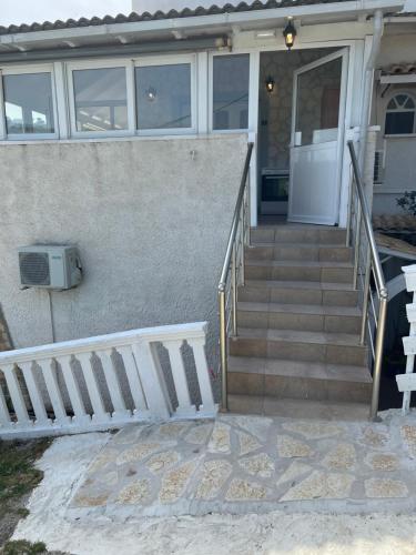 a house with a staircase leading to the front door at Hamre Apartments (Nicholas) in Agios Georgios Pagon