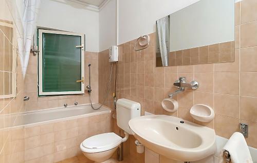 a bathroom with a white toilet and a sink at Villa Olivenbaum in Kastel Stafilic