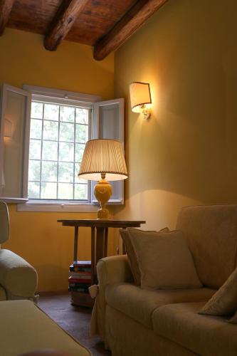 a living room with a couch and a table with a lamp at BORGO GIUSTINIANI Mora Pero Melo in San Martino di Venezze