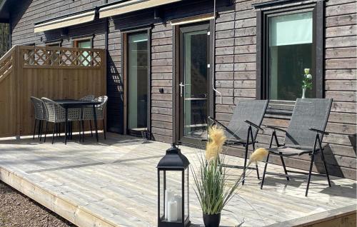 a wooden deck with chairs and a table on it at 3 Bedroom Lovely Home In Säffle in Säffle