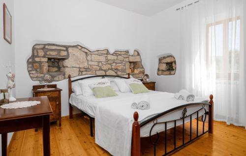a bedroom with a large bed with a stone wall at 4 Bedroom Stunning Home In Vlasici - Krsan in Kršan