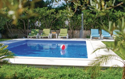 uma piscina com uma bola vermelha na água em Villa Olivenbaum em Kaštel Štafilić