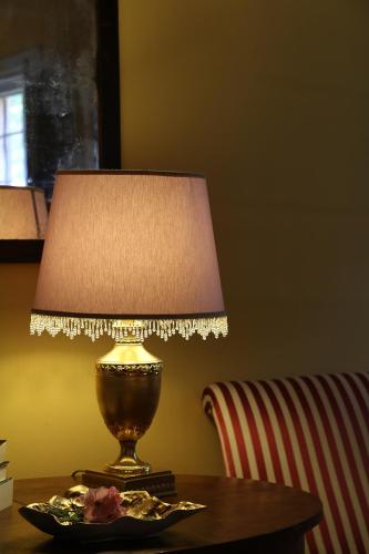 a lamp sitting on top of a table next to a chair at BORGO GIUSTINIANI Mora Pero Melo in San Martino di Venezze