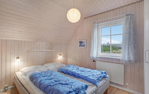 KlegodにあるAwesome Home In Ringkbing With Saunaのベッドルーム1室(青い毛布付きのベッド1台付)