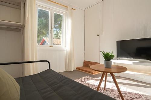 a room with a bed and a table and a tv at Cabaña en la costa de Pelluhue in Pelluhue