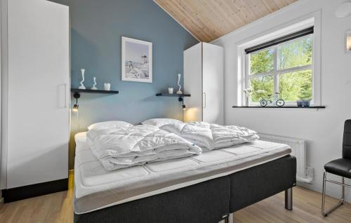 a bedroom with a bed with blue walls and a window at Beautiful Home In Vig With Wifi in Vig