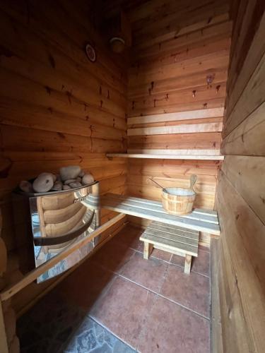 una sauna de madera vacía con un banco y un cubo en Janune Kägu, en Koeru