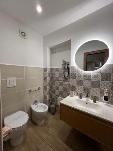 W łazience znajduje się toaleta, umywalka i lustro. w obiekcie Dimora del Pescatore - Holiday House w Cefalù