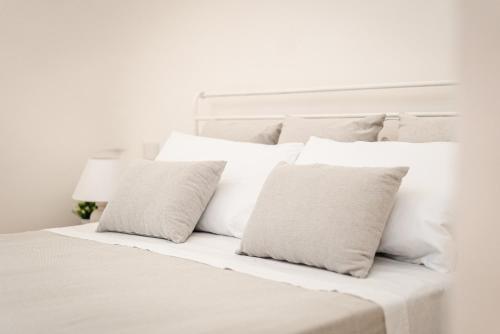 Una cama blanca con almohadas blancas. en Trulli del 1800 con Foresta, Wi-Fi e Biciclette, en Cisternino