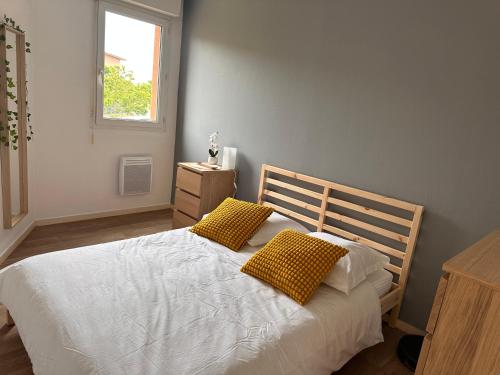 ブラニャックにあるCharming one bedroom apartment, - pres des commerces et tram FIBRE wifi, Airbus MEET super locationのベッドルーム1室(白いベッド1台、黄色い枕2つ付)