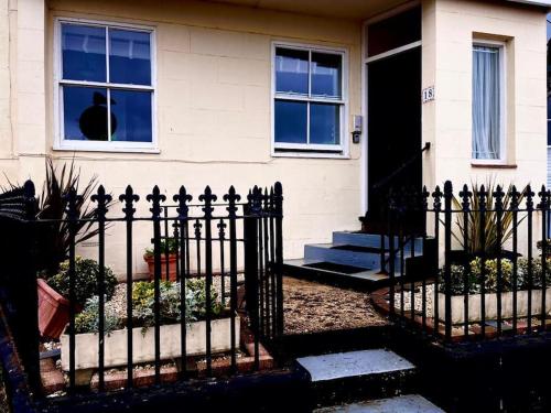 una cerca frente a una casa en Seafront & Dog Friendly Beautiful Ground Floor Flat, en Kent