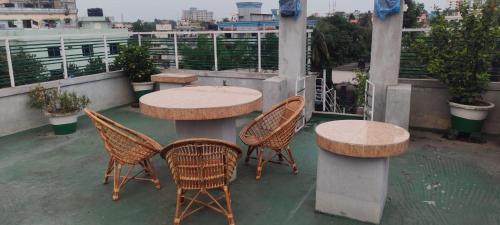 un patio con 2 mesas y sillas en un balcón en Zuned Homes Sylhet, en Sylhet