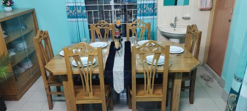 a wooden dining room table with chairs and an umbrella at Zuned Homes Sylhet in Sylhet