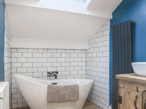 a bathroom with a white tub and a sink at Castlebergh Cottage in Settle