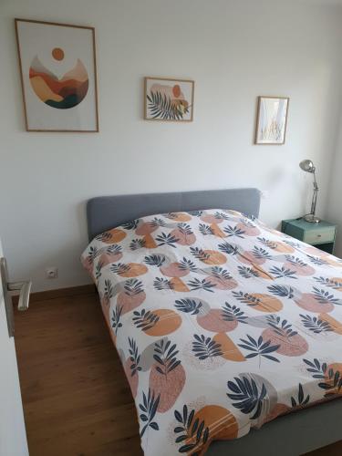 - une chambre dotée d'un lit avec un couvre-lit floral dans l'établissement L'Obernois situé dans 1 résidence privée, à Obernai