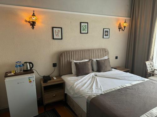 1 dormitorio con 1 cama y 1 mesa con teléfono en Sur Central Hotel, en Diyarbakir