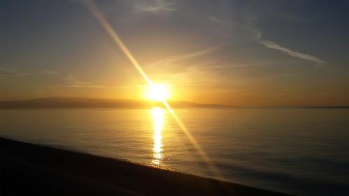 a sunset over the ocean with the sun setting at Borgo Marino casa vacanze in Santa Teresa di Riva