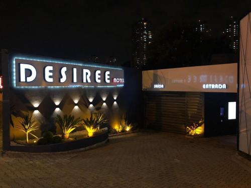 een gebouw met een bord dat 's nachts prestige zegt bij Motel Desireé in Sao Paulo