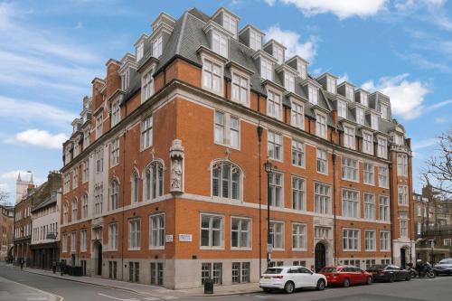 a large brick building with cars parked in front of it at Sonder The Arts Council in London