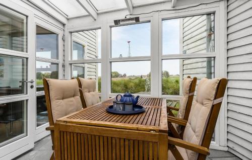 a screened in porch with a table and chairs at Stunning Home In Stege With Sauna in Stege