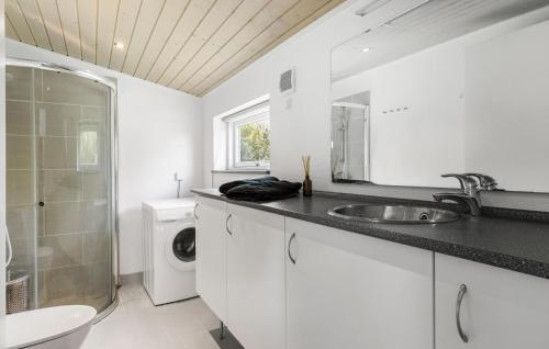 y baño blanco con lavabo y lavadora. en Gorgeous Home In Stege With Kitchen en Stege