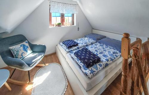 ノベ・バルプノにあるAwesome Home In Nowe Warpno With Wifiの小さなベッドルーム(ベッド1台、椅子付)