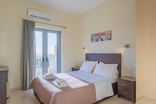 a bedroom with a large bed with a window at Sundy Maria Apartments in Stoupa