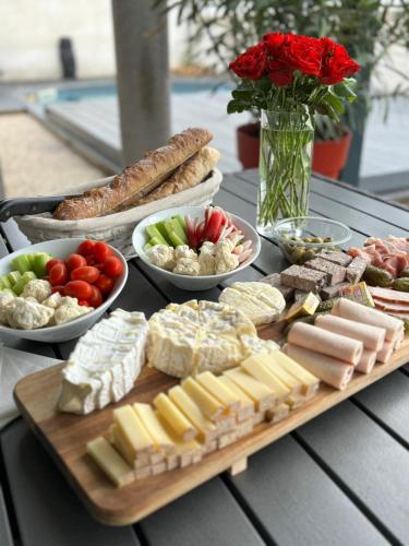 a table topped with different types of cheese and vegetables at La Maison de Jade & Spa in La Roche-de-Glun
