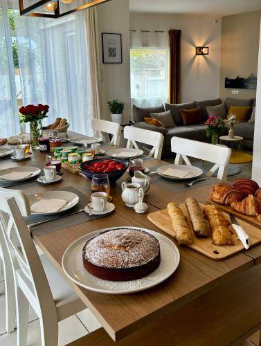 a dining room table with a cake and pastries on it at La Maison de Jade & Spa in La Roche-de-Glun