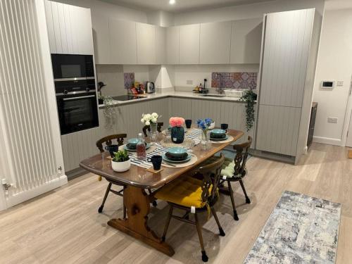 uma cozinha com uma mesa de madeira com flores em Stay@Inaara Property-Contemporary 2 Bedroom Apartment with Ensuite em Londres